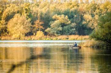 Fototapeta premium Begec, Serbia - October 30. 2021: Sport fisherman in a boat on an artificial lake near Novi Sad.