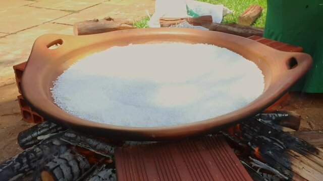 Frying beiju or a large tapioca crepe in a large flat clay pot - indigenous traditional, tribal recipe from the Amazon rainforest