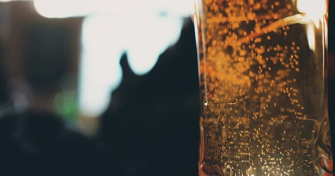 Close up footage of bubbles rising inside a glass of beer.