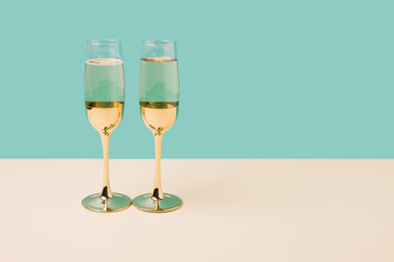 Romantic champagne glasses set up on a turquoise background. Minimal Valentines concept	