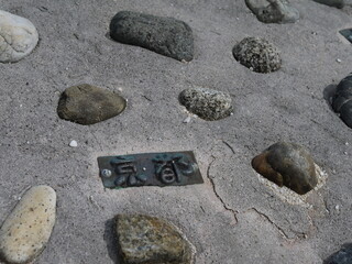 Fototapeta na wymiar アスファルトに埋められた石と京都のタイル