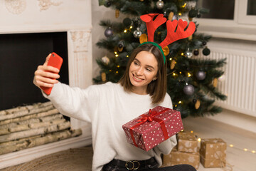The young girl telephone to parents and show a red Christmas gift
