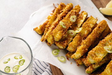 sliced zucchini baked in breading, diet appetizer, restaurant serving, sour cream sauce and lime wedges