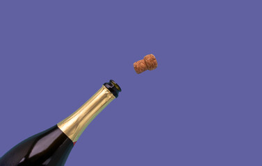 A bottle of champagne and a cork are open on a very peri lilac background