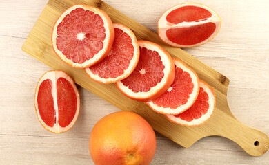 Pieces of grapefruit on a wooden cutting board. View from above