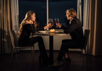 Valentine's day festive dinner, couple in love at home drinking wine in glasses, date romantic...
