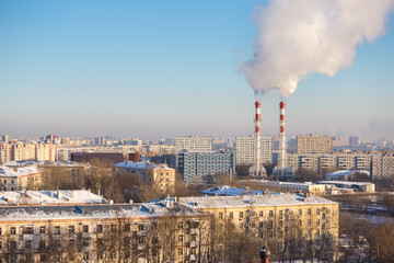 View of the city on a clear frosty day. Pipes of the city boiler house with thick steam.