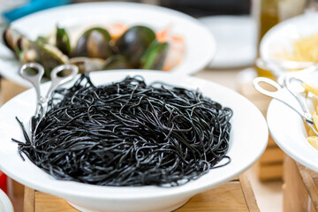 black pasta with cuttlefish ink on plate. Black fresh spaghetti pasta with squid ink on plate.