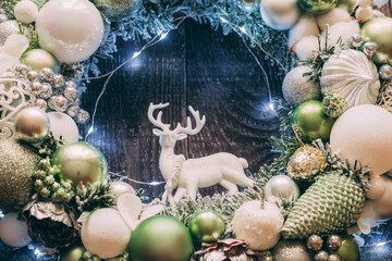 Obraz na płótnie Canvas Christmas wreath with deer close-up. Lights on the wreath.