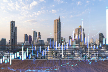 Rooftop with wooden terrace, Bangkok sunset skyline. Forecasting and business modeling of financial markets hologram digital charts. City downtown. Double exposure.