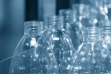 The close-up scene of empty PET bottles  on the conveyor belt for filling process in the drinking water factory.