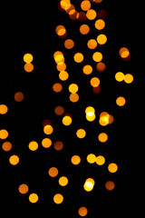 Christmas or New Year golden blurred bokeh lights on black background