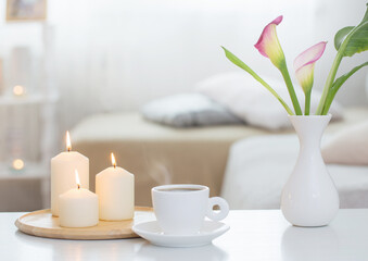 Fototapeta na wymiar cup of coffee and flowers in vase on white table indoor
