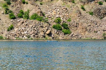 Sporty man on sup board with paddle in the lake