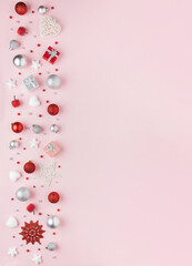 Beautiful pink greeting card with red and sliver Christmas ornaments and baubles border and copy space