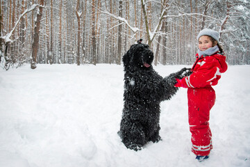 Fototapeta na wymiar In winter, snow falls in the snowy forest, two little girl play