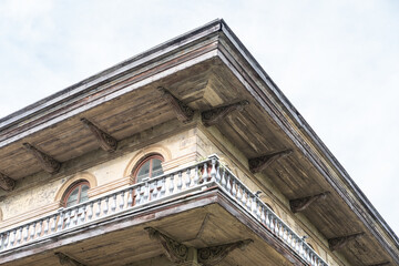 Wraparound balcony and upper corner of historic mansion showing architectural details of Italianate...