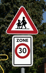 Panneau de signalisation d'une école et d'une zone 30.