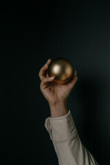 woman holding a golden matte christmas tree bauble. High quality photo