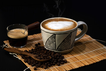 hot latte with coffee beans on dark background