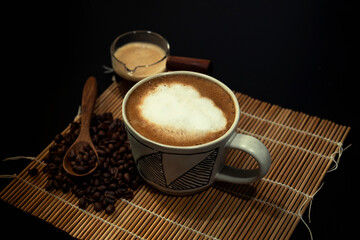 hot latte with coffee beans on dark background