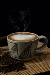hot latte with coffee beans on dark background