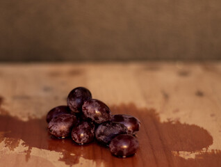 Obraz premium The wine is born from the grape, photography on black background and wooden table