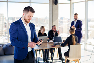 Business people, businessmen are working together in a modern office in a multi-storey skyscraper. The director is on the phone. Office work concept. Selective focus