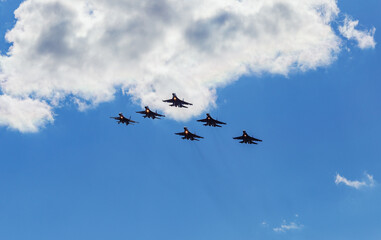 A link of jet military, fighters, aircraft perform a maneuver against the background of the clouds...