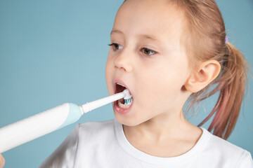 Adorable little caucasian child brushing teeth Standing Over blue Background