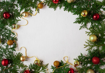 Fototapeta na wymiar Christmas or New Year background: fir branches on a white background with Christmas balls. White frame for congratulations
