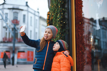 brother and sister making selfie at christmas decoration