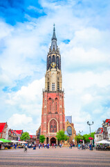 Fototapeta na wymiar Nieuwe Kerk tower and traditional houses on Market square of old beautiful city Delft, Netherlands