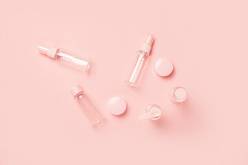 Empty tubes for cosmetics on a pastel pink background. Flat lay, top view. Banner