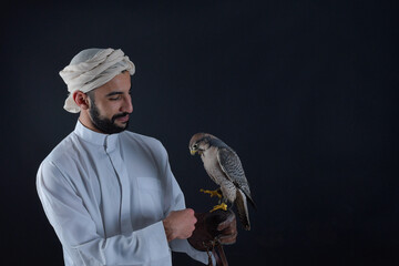 Young falconer holding a bird of prey.