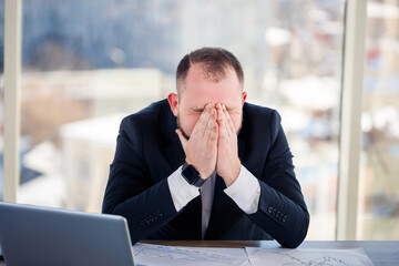 Adult male businessman, teacher, mentor is working on a new project in the office and is nervous....
