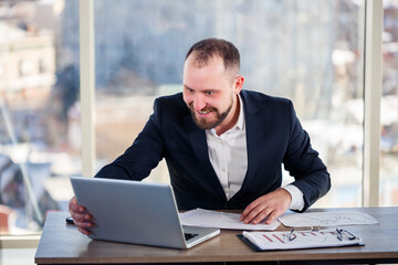 Adult successful male businessman, teacher, mentor is working on a new project. Sits at the table...