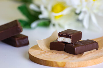 cioccolatini con ripieno a doppio strato sul asse e fiori in fondo