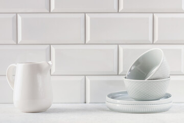 Kitchen utensils - plates, bowls, jug on a bright background