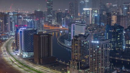 Fototapeta premium Skyline with modern architecture of Dubai business bay towers night timelapse. Aerial view