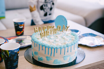 Fototapeta na wymiar Festive blue and white birthday cake is on the table