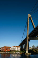 Naklejka premium Scenic cityscape of modern norwegian town. Modern architecture of Stavanger. Sunny day. Huge bridge over fjord.