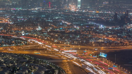 Fototapeta na wymiar Top view city traffic on a big crossroad in Business bay night timelapse.