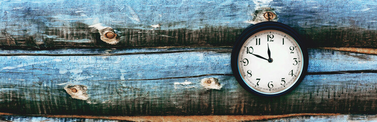 Old clock hanging on wall of logs. Panorama.