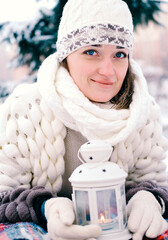 The girl lies on the snow in the winter forest or park. Concept - Christmas vacations and holidays.