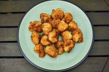 Vegan cauliflower buffalo wings on white wooden table.Tasty vegetarian food top view. crispy fried cauliflower bites