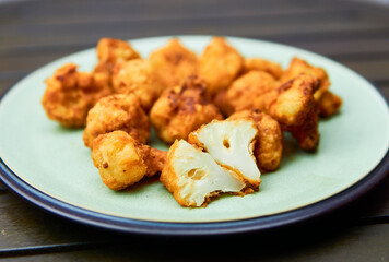 Vegan cauliflower buffalo wings on white wooden table.Tasty vegetarian food top view. crispy fried cauliflower bites