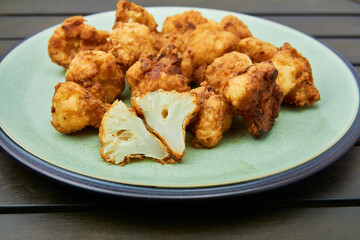 Vegan cauliflower buffalo wings on white wooden table.Tasty vegetarian food top view. crispy fried cauliflower bites