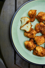 Vegan cauliflower buffalo wings on white wooden table.Tasty vegetarian food top view. crispy fried cauliflower bites