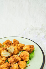 Vegan cauliflower buffalo wings on white wooden table.Tasty vegetarian food top view. crispy fried cauliflower bites